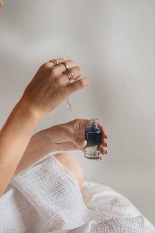Person dispensing skincare serum onto their hand using a pipette